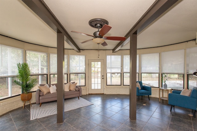 sunroom featuring lofted ceiling with beams and ceiling fan