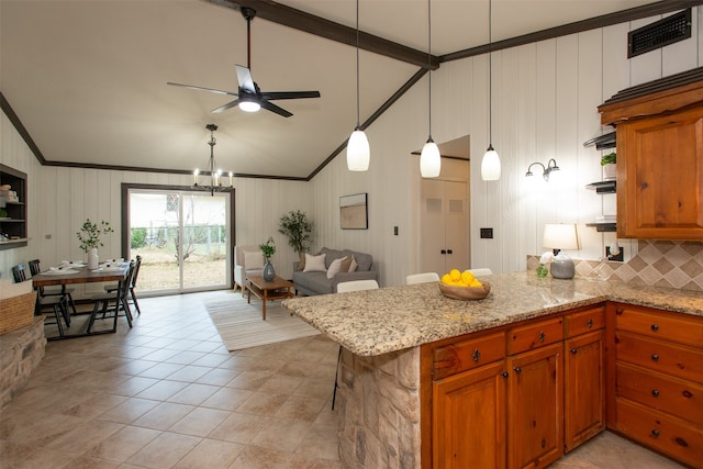 kitchen with light stone countertops, kitchen peninsula, decorative backsplash, and hanging light fixtures