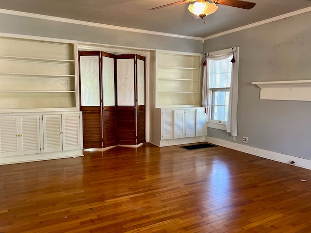 spare room with dark wood-type flooring, crown molding, and ceiling fan