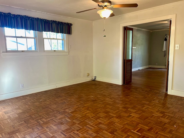 spare room featuring crown molding, dark parquet floors, and ceiling fan