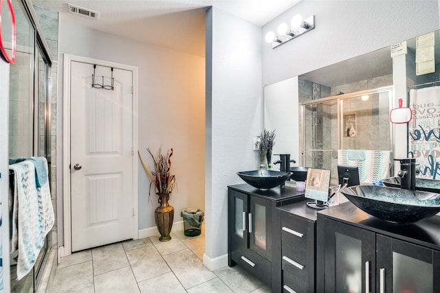 bathroom with vanity, tile patterned floors, and a shower with door