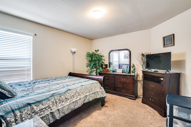 bedroom with light carpet and a textured ceiling