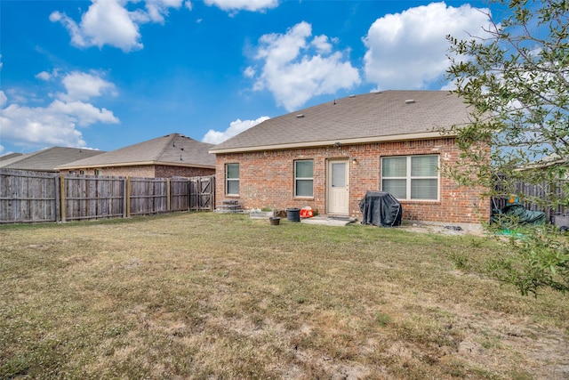 2209 Torch Lake Dr, Forney, TX 75126 - back of property featuring a fenced backyard, a shingled roof, a lawn, and brick siding