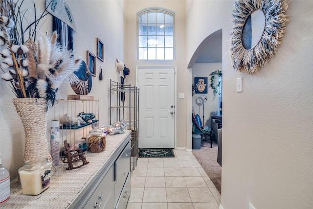 2209 Torch Lake Dr, Forney, TX 75126 - interior space featuring arched walkways, light colored carpet, light tile patterned flooring, and a towering ceiling