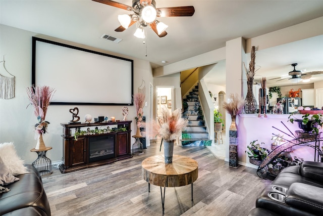 2209 Torch Lake Dr, Forney, TX 75126 - cinema room featuring a glass covered fireplace, ceiling fan, wood finished floors, and visible vents