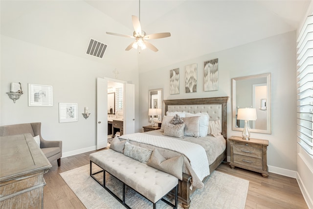 bedroom with high vaulted ceiling, ceiling fan, light hardwood / wood-style flooring, and connected bathroom