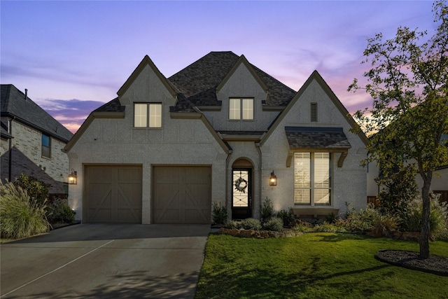 french country inspired facade featuring a yard and a garage