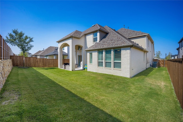 rear view of property with a yard, cooling unit, and a patio area