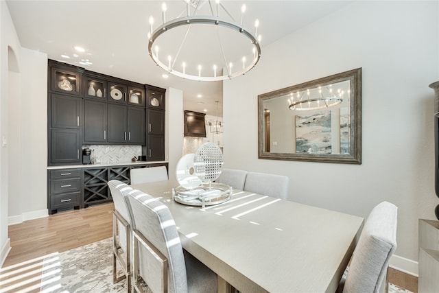 dining space featuring an inviting chandelier and light wood-type flooring