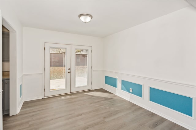 empty room with french doors and light wood-type flooring