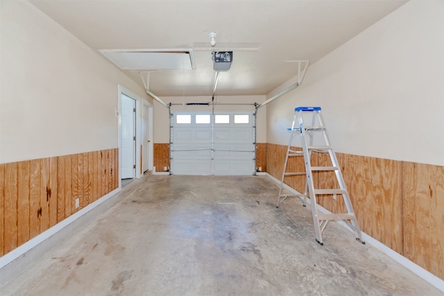 garage with a garage door opener and wooden walls