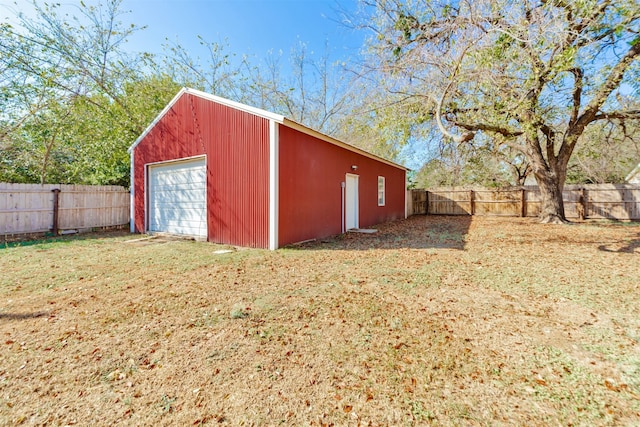 view of outdoor structure featuring a garage and a lawn