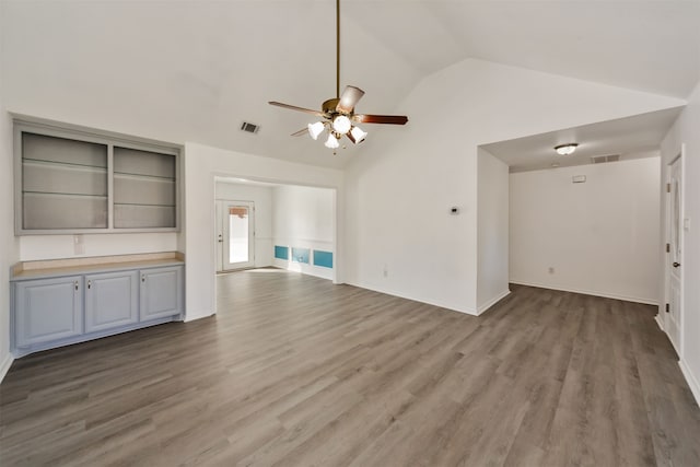 unfurnished living room featuring lofted ceiling, hardwood / wood-style flooring, and ceiling fan