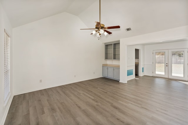 unfurnished living room with french doors, ceiling fan, hardwood / wood-style flooring, and lofted ceiling