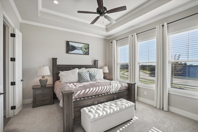 carpeted bedroom featuring a tray ceiling, ceiling fan, and ornamental molding