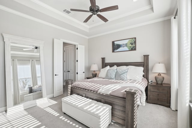 bedroom with a raised ceiling, ceiling fan, crown molding, and light colored carpet