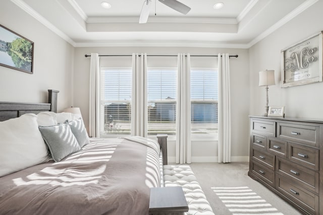 bedroom with a raised ceiling, ceiling fan, light colored carpet, and crown molding