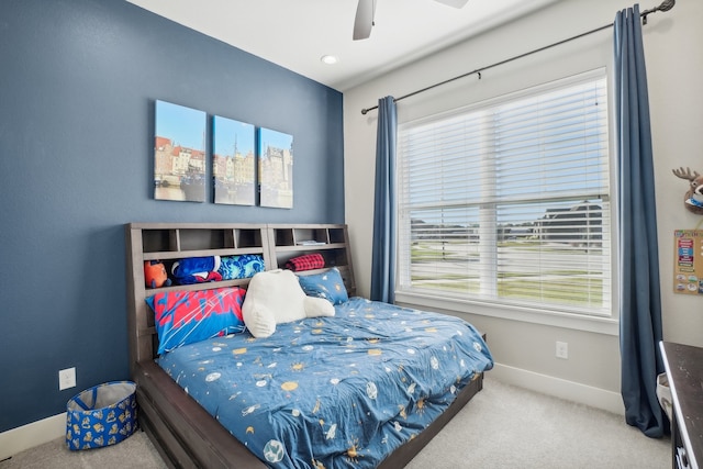 carpeted bedroom with ceiling fan and multiple windows