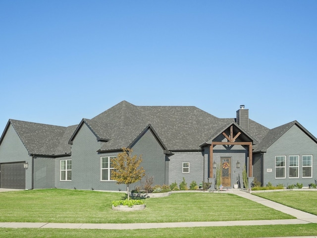 french country home featuring a front yard and a garage