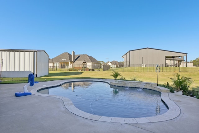 view of pool with pool water feature and a yard