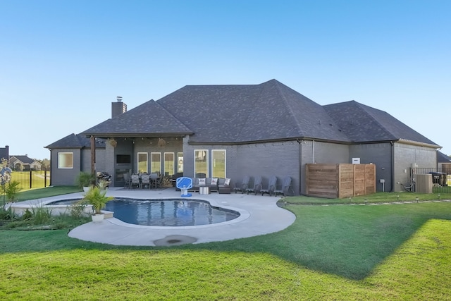 back of property with a lawn, a patio area, and central AC