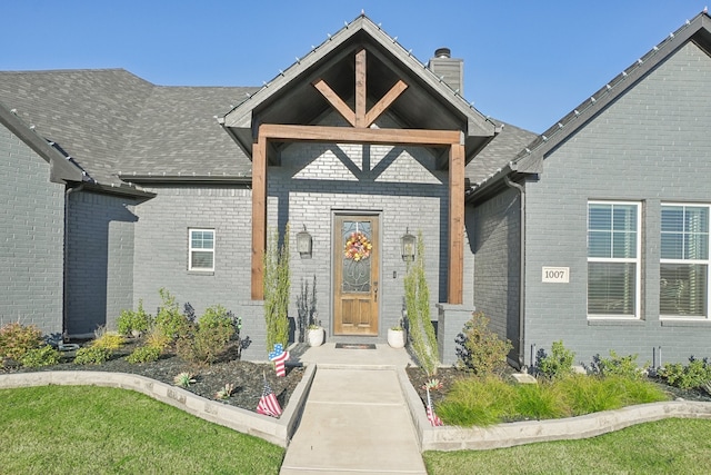 property entrance with a lawn