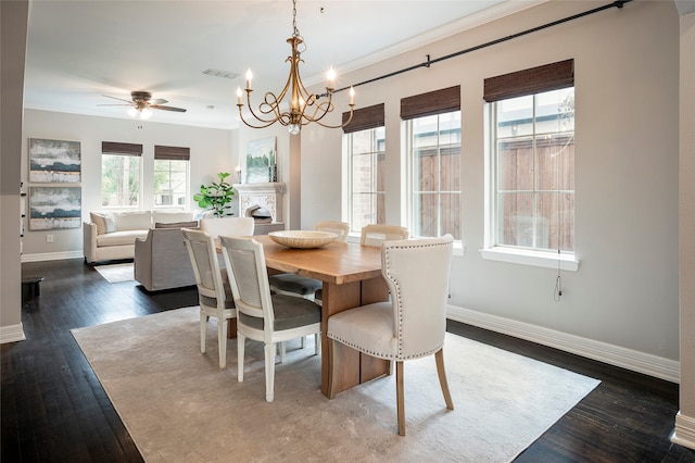 dining space featuring crown molding, ceiling fan with notable chandelier, and dark hardwood / wood-style flooring