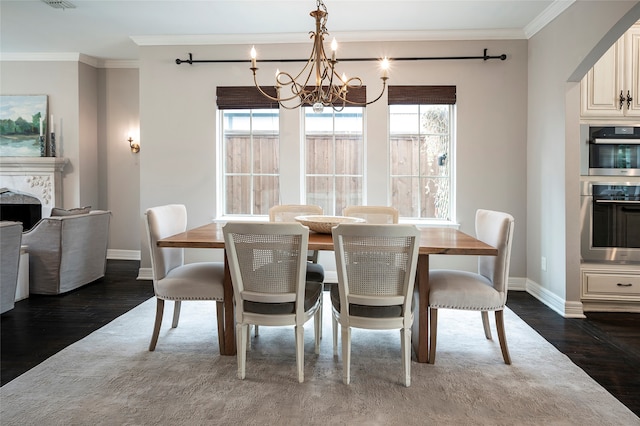 dining area featuring ornamental molding, dark wood-type flooring, and an inviting chandelier