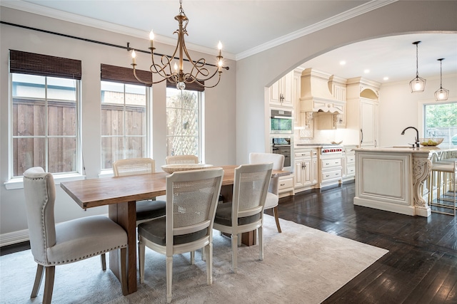 dining space with ornamental molding, a notable chandelier, dark hardwood / wood-style floors, and a healthy amount of sunlight