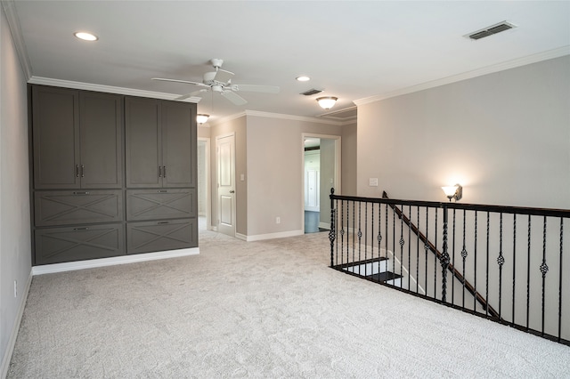 spare room with crown molding, light colored carpet, and ceiling fan