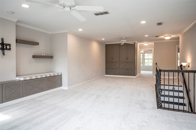 unfurnished living room with ceiling fan, ornamental molding, and light colored carpet