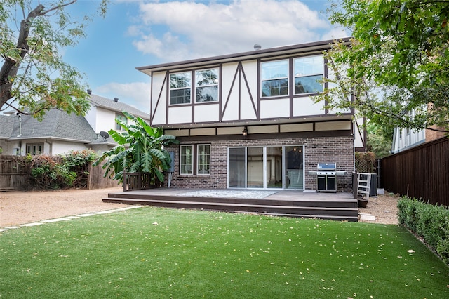 rear view of house featuring a deck and a lawn