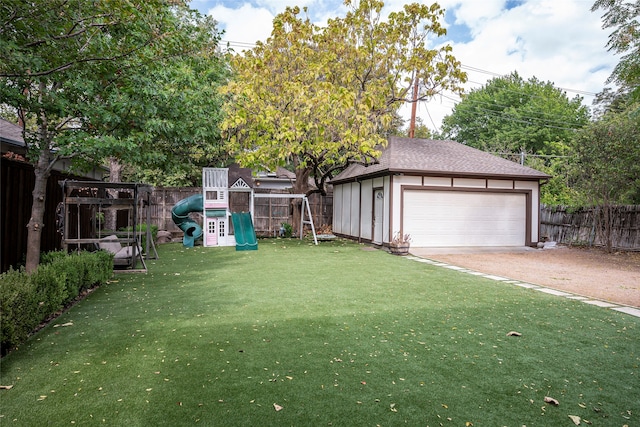 view of yard featuring a playground and a garage