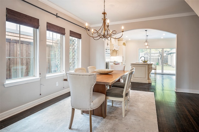 dining space featuring crown molding, a notable chandelier, and dark hardwood / wood-style flooring