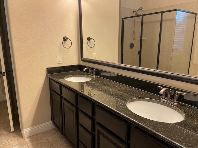 bathroom with vanity, a shower with shower door, and tile patterned floors