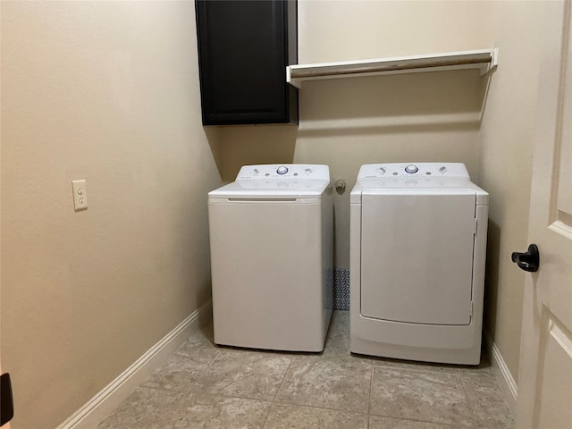 clothes washing area with cabinets and separate washer and dryer