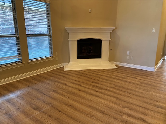 unfurnished living room with wood-type flooring and plenty of natural light