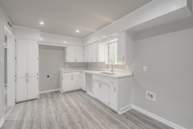 kitchen with light hardwood / wood-style floors, sink, and white cabinets