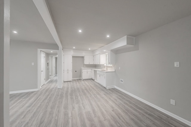 unfurnished living room featuring light wood-type flooring and sink