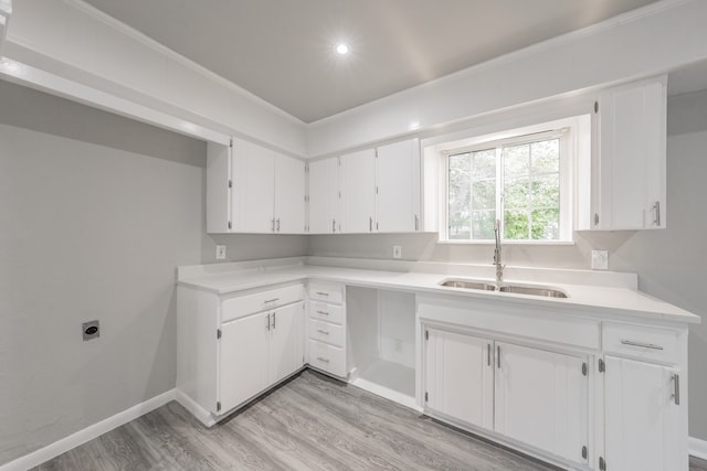 kitchen with sink, white cabinets, light hardwood / wood-style flooring, and crown molding