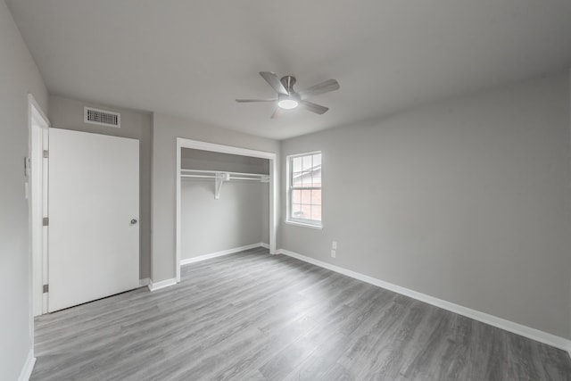 unfurnished bedroom featuring ceiling fan, a closet, and light hardwood / wood-style flooring