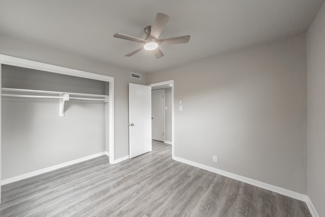 unfurnished bedroom featuring light wood-type flooring, ceiling fan, and a closet