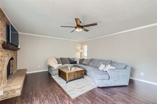 living room with ceiling fan, dark wood-type flooring, ornamental molding, and a brick fireplace