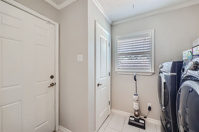 laundry area with washing machine and dryer, light tile patterned floors, and ornamental molding