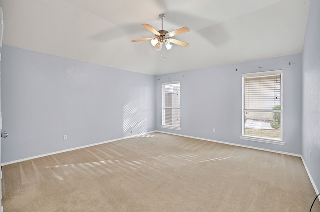 carpeted spare room featuring a healthy amount of sunlight and ceiling fan