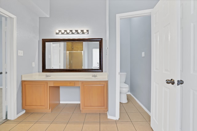 bathroom with vanity, toilet, tile patterned floors, and a shower with shower door