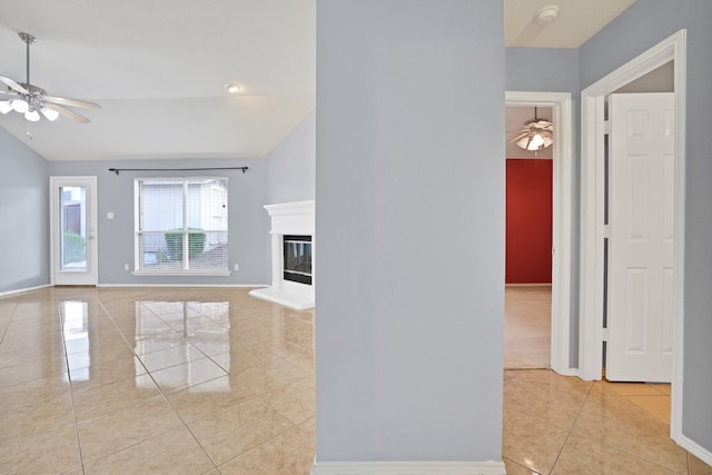 unfurnished living room with lofted ceiling, ceiling fan, and light tile patterned floors