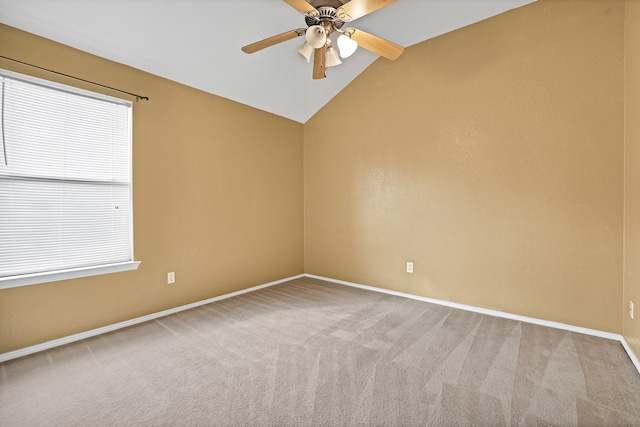 spare room with carpet floors, ceiling fan, a wealth of natural light, and vaulted ceiling