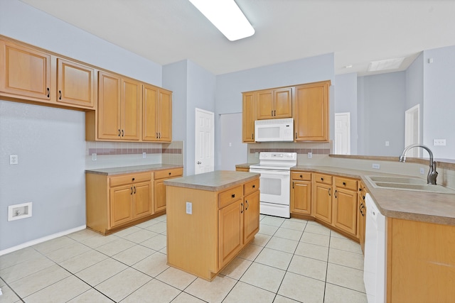 kitchen with kitchen peninsula, sink, a center island, light tile patterned floors, and white appliances