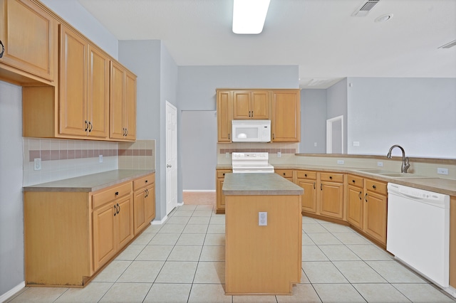 kitchen with white appliances, light brown cabinetry, sink, a center island, and light tile patterned floors